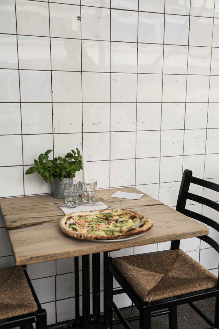A freshly baked pizza sits on a rustic wooden table in a cozy indoor setting.